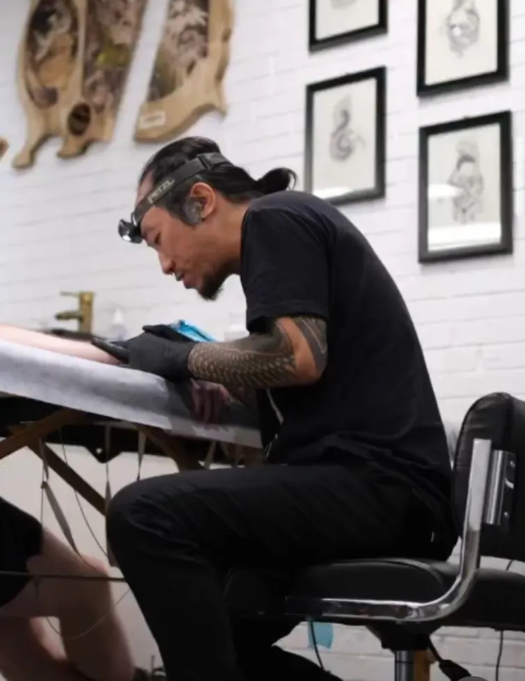 Tattoo artist Thu Vo Le working in his professional studio in the USA